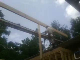 Carpenter setting a ridge beam over a new addition frame — Ice Dam Removal by Roofing Brothers in Mount Wolf