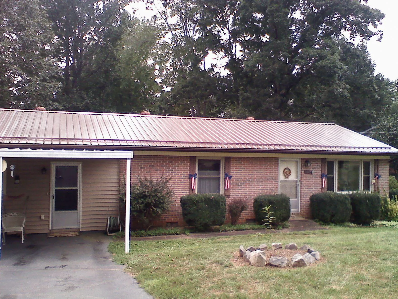 Bronze metal roof and carport on a brick ranch home — Roof Repair work by our crew in Mount Wolf